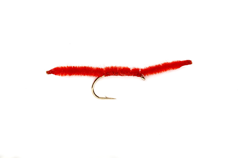 Red San Juan Worm tied on a curved hook — vernille body with burnt-taper ends, the default color for high, stained, post-rain water